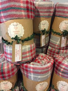 several rolls of red and white plaid fabric wrapped in brown paper with labels on them