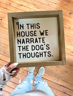 a person holding up a sign that says in this house we narrate the dog's thoughts