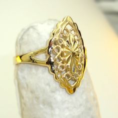 Anillo de oro 10k con diseño de almendra calada Un accesorio elegante y sofisticado para mujeres Esta sortija de oro 10k es una pieza impresionante con un diseño de almendra calada, que se destaca por su tejido alrededor de la misma, similar a la técnica de la filigrana. El resultado es una joya única, muy elegante y sofisticada que complementará cualquier atuendo y agregará un toque extra de estilo y glamour. La sortija está hecha de oro de 10 quilates de color amarillo, que es un material dura Elegant 14k Yellow Gold Filigree Ring, Elegant Marquise Ring With Intricate Design, Elegant Yellow Gold Filigree Ring For Anniversary, Yellow Gold Filigree Jewelry Ring, Elegant 14k Gold Rings With Intricate Design, Elegant Yellow Gold Filigree Wedding Ring, Formal Marquise Jewelry With Intricate Design, Elegant Oval Filigree Ring With Diamond Cut, Oval Filigree Ring With Diamond Cut In 14k Gold