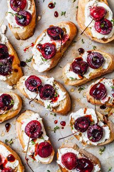 cranberry and goat cheese bruschets on a sheet of parchment paper