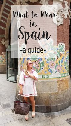 a woman standing in front of a sign that says what to wear in spain - a guide