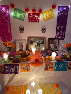 a decorated table with candles and pictures on it