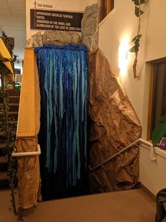 there is a waterfall made out of brown paper and blue streamers on the wall