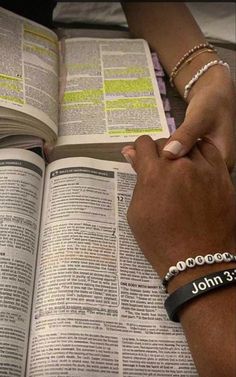 two people holding hands over an open book with the words john 3 13 on it