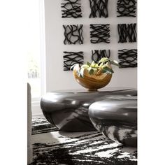 a black and white area rug with various pieces of art on the wall behind it