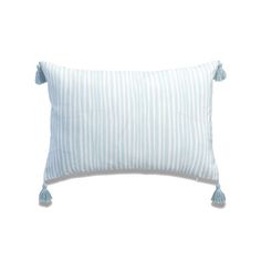 a blue and white striped pillow with tassels on the edges, sitting against a white background