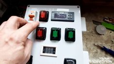 a person is pressing buttons on a white board with green and red buttons in front of them