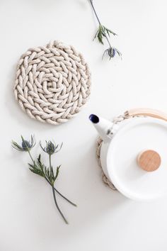 a white table topped with flowers and a teapot on top of a saucer