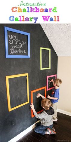 two young boys are playing with chalkboards on the wall