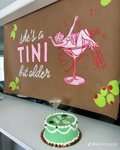 a cake sitting on top of a counter next to a sign that says she's a tini but older