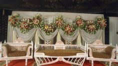 an elaborately decorated living room with white furniture and flowers on the drapes