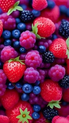 berries, raspberries and blueberries are piled together