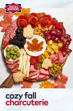 a platter filled with meats, cheeses and vegetables on top of leaves