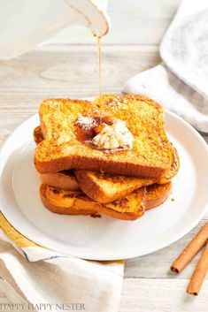 toasted french toast on a white plate with butter and cinnamon syrup being drizzled over it