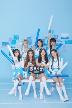 a group of young women sitting next to each other on top of a blue bench