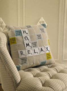 a chair with a pillow that has scrabble letters on it