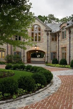 a large brick house surrounded by lush green trees