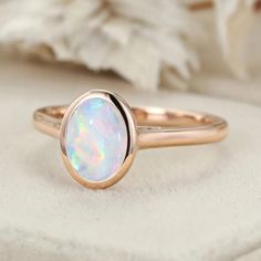 a white opal ring sitting on top of a cloth