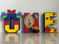 the word noel spelled out in 3d letters with flowers and an apple on each letter