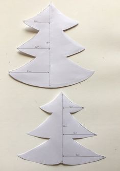 two paper christmas trees cut out to look like they are being made