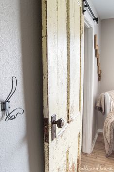 an open door leading to a bedroom with a bed in the corner and a wall hook