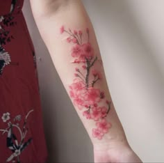 a woman's arm with pink flowers on it