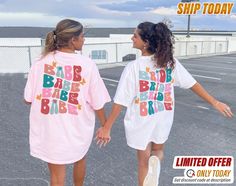 two girls in matching shirts are walking together