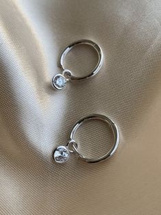 14K White Gold plated 925 Sterling Silver Charm Hoop Earrings. Minimalist style. Everyday jewelry made with love. DETAILS * 14K White Gold Plated * 925 Sterling Silver * AAA Cubic Zirconia Stone * Lead Free and Nickel Free MEASURES Hoop Diameter: 12mm (1.2cm) Charm Size: 5mm (0.5cm) *Sell as a pair PACKAGE: All jewelry comes in beautiful packaging, gift ready. ABOUT FALA All our work is made with love in Santa Monica, California. We love our customers and will make sure you're well taken care of Silver Earrings Aesthetic, Silver Huggie Earrings, Simple Silver Earrings, Small Silver Hoop Earrings, Dope Jewelry Accessories, Huggie Earrings Silver, Small Gold Hoop Earrings, Hoop Earrings Silver, Prom Earrings