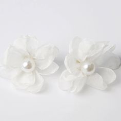 two white flowers with pearls on them