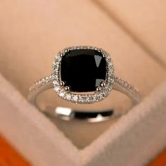 a black diamond ring sitting in a box