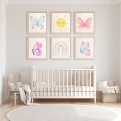 a baby's room with four paintings on the wall and a white crib