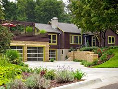 a large house with lots of trees and plants in front of the garage door is surrounded by greenery