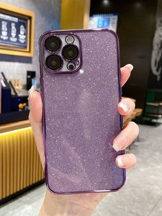 a woman holding up her purple phone case in front of the camera with two buttons on it