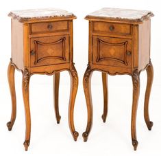 two wooden nightstands with marble tops on each side, one is turned upside down