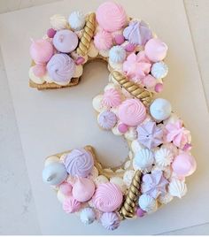 the letter s is made out of cookies and marshmallows with pastel colors