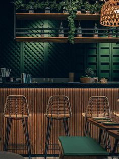 the interior of a restaurant with bar stools and wooden tables in front of it