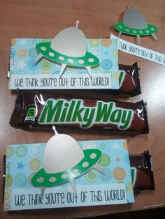 three candy bar wrappers sitting on top of a wooden table