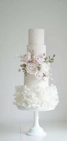 a three tiered white cake with flowers on top