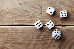 four dices laying on top of a wooden table