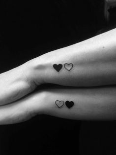 two people with matching tattoos on their feet, one holding the other's hand