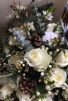 a bouquet of white flowers and pine cones