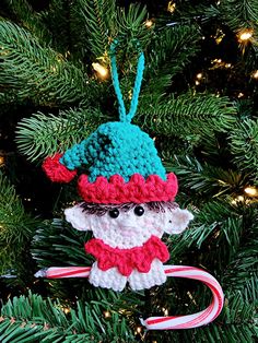 a crocheted ornament hanging from a christmas tree with candy canes