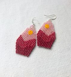 These darling seed bead earrings feature a mountain scene gradient of red and pink inspired by the beautiful Rocky Mountains. They hang approximately 1.75 inches from the lobe and measure 1 inch across their widest point. Beads and Earwires: Each pair is handmade with the highest quality size 11 Miyuki Delica beads. The closure is a sterling silver finding. If you have specific sensitivities I can make your earrings with gold plated findings, just let me know! Packaging: All earrings are individ Gift Red Beaded Earrings With Bead Caps, Teardrop Earrings With Bead Caps As A Gift, Teardrop Earrings With Bead Caps For Gifts, Bead Cap Drop Earrings As Gift, Bead Caps Drop Earrings As Gift, Bead Cap Drop Earrings For Gift, Pink Beaded Dangle Earrings With Bead Caps, Pink Dangle Beaded Earrings With Bead Caps, Pink Beaded Earrings With Bead Caps As Gift