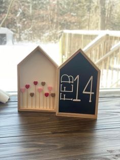 two small houses with candles in them on a table