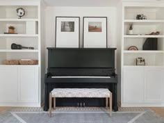 there is a piano in the corner of this living room with white bookcases