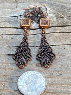 Long antique copper filigree earrings with Czech crystal and garnet gemstones. These long filigree earrings are very lovely, not too heavy! They are 3 inches long and 3/4 of an inch wide. The square table Kurt Czechoslovakian crystals really make the design pop. Garnet is the birthstone for January. All my jewelry comes gift boxed with a custom Shelly Mariposa Design butterfly card ready for gift giving, whether it is a gift for you or someone special. Your satisfaction is very important to me. Antique Finish Copper Dangle Earrings, Antique Gold Copper Earrings With Antique Finish, Antique Finish Copper Drop Earrings, Ornate Copper Jewelry With Antique Finish, Bronze Copper Pierced Earrings, Bronze Copper Earrings For Pierced Ears, Bronze Copper Earrings, Ornate Antique Finish Copper Jewelry, Ornate Antique-finish Copper Jewelry