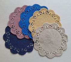 four crocheted doily on a white surface