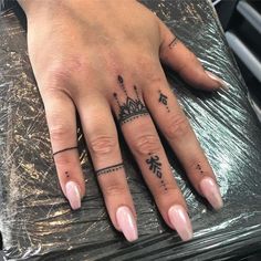 a woman's hand with two different tattoos on it and one has a crown