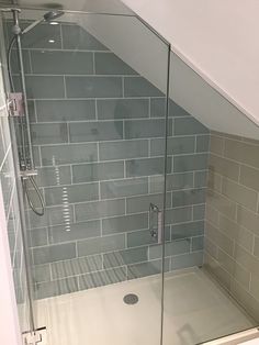 a walk in shower sitting under a slanted ceiling