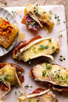 several pieces of bread with cheese and bacon on them sitting on a white platter